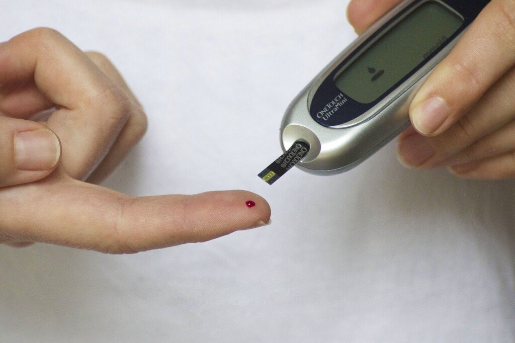 Diabetes, Persona controlando el nivel de azúcar en sangre con un medidor de glucosa en casa.