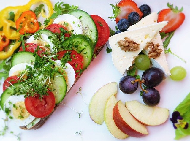 Grupos de personas preparando comidas saludables con frutas y verduras frescas.